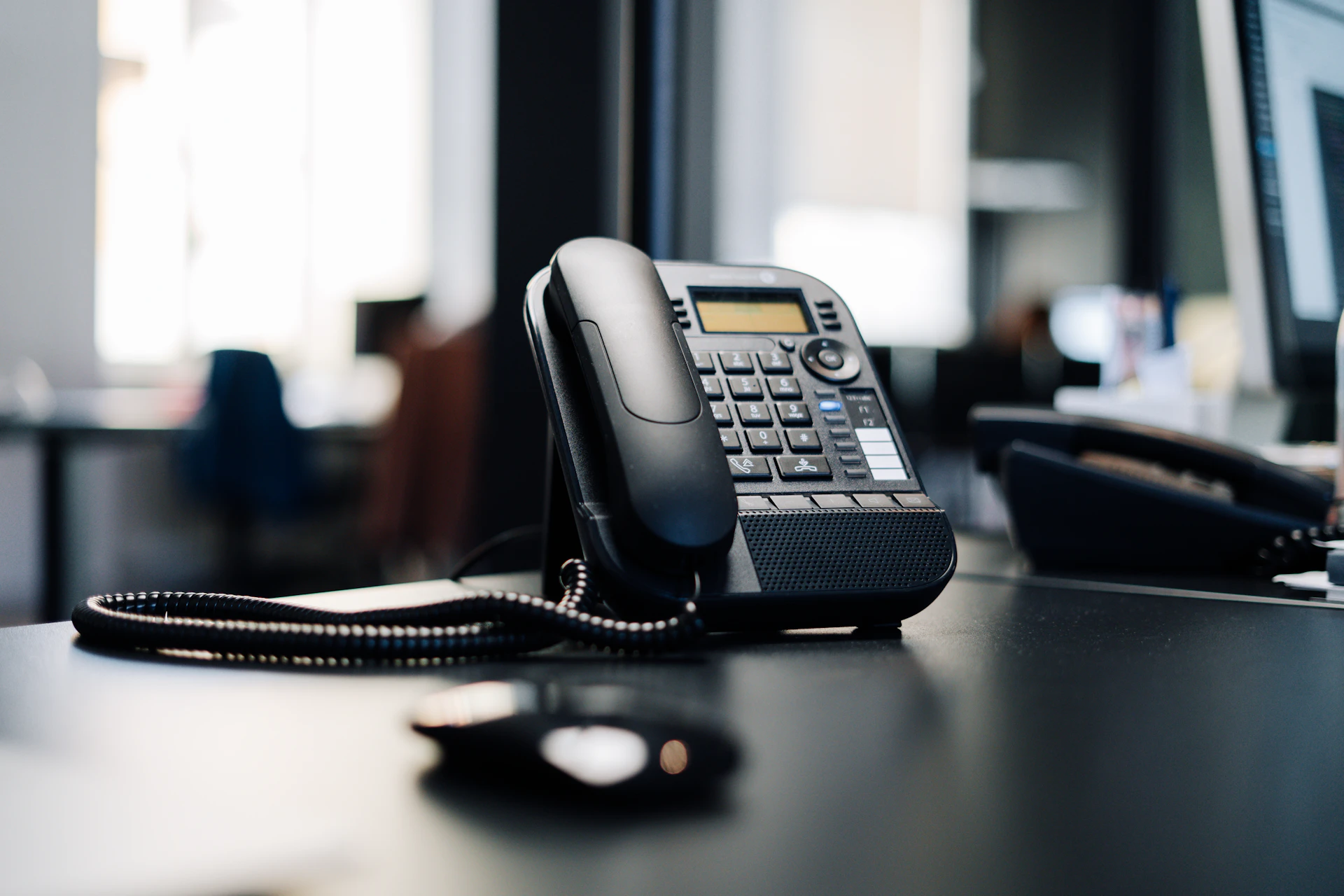 Schwarzes Tischtelefon in einem Büro