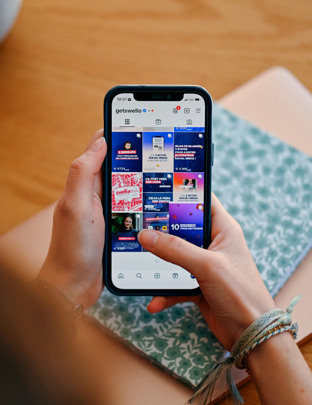 Hände halten ein Smartphone mit buntem Social-Media-Feed
